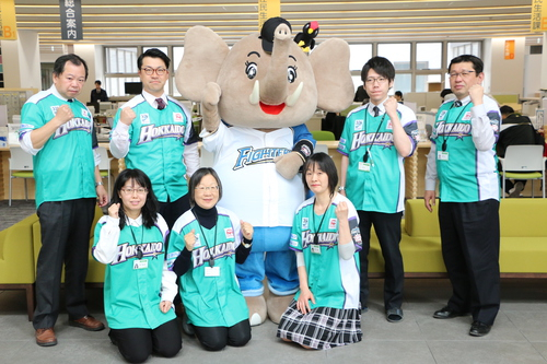 北海道日本ハムファイターズのユニフォームを着たパオ君と職員の写真